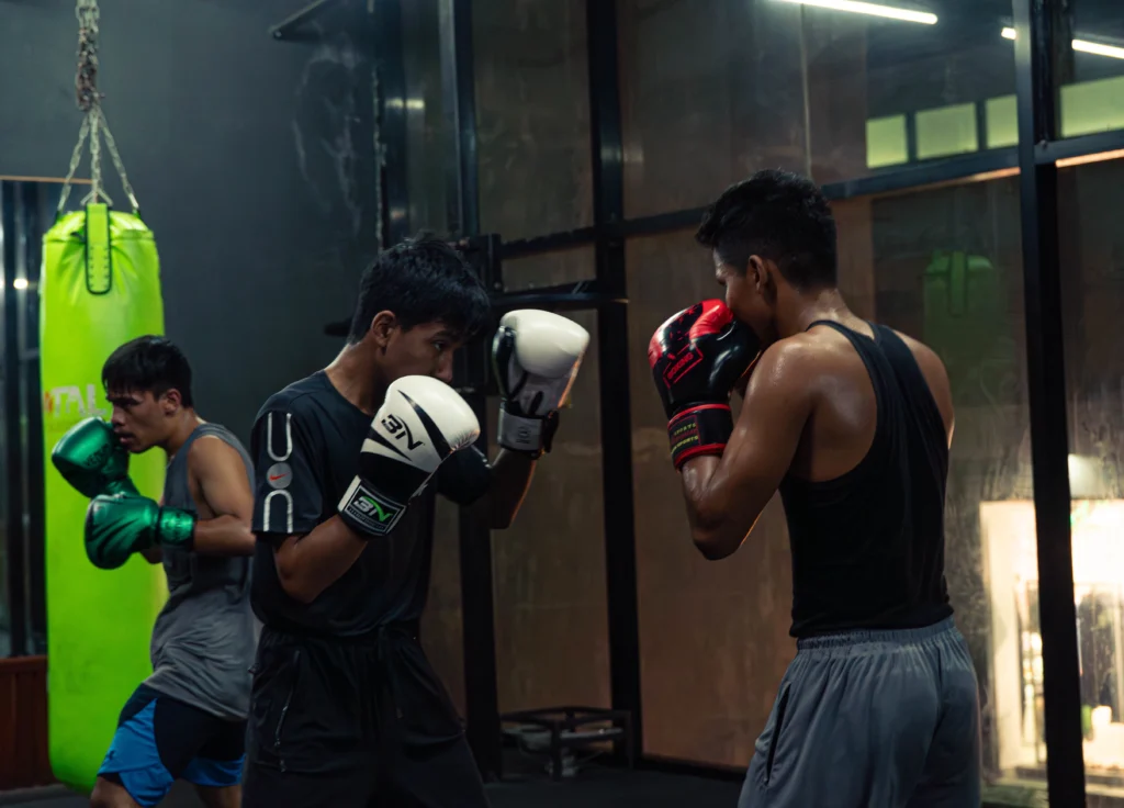 Boxing classes at top fitness center in Kathmandu TPFC (Total Physical Fitness Center) with athletes practicing punches and pad work inside the boxing area