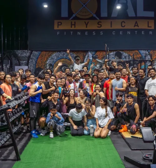 Large group of members gathered inside Total Physical Fitness Center during an energetic training session, highlighting community engagement in cardio and gym activities.