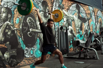 Athletes performing strength and weightlifting exercises inside a modern weightlifting section in best fitness center in Kathmandu- named total physical fitness center in Kathmandu